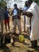 A hydrologist shows citizen scientists how to use simple equipment (a yellow plastic bucket tied to a long length of string) to measuring shallow groundwater levels via a small well, Ethiopia thumbnail